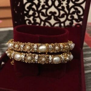 Elegant gold plated bangles set with beautiful pearl and stone detailing. A traditional designer style perfect for weddings, bridal wear, and festive occasions.